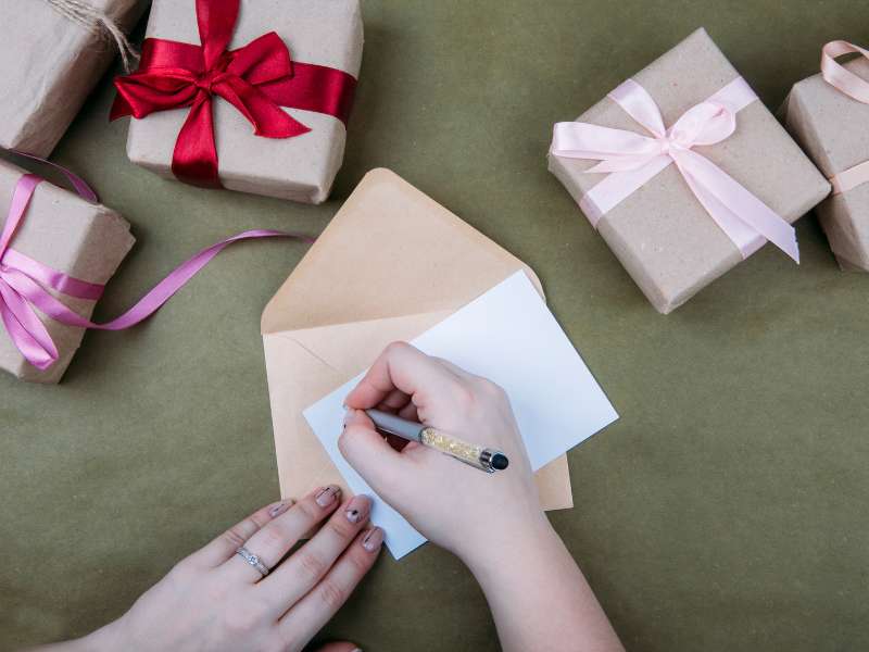 Une personne est en train de remplir un bon cadeau pour l'offrir à une autre