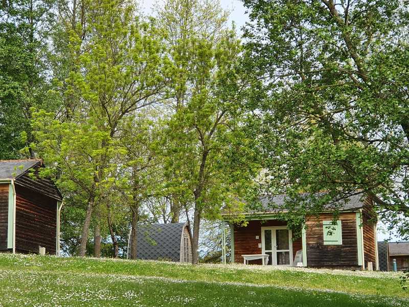 Des chalets sont disposés sur le terrain d'un camping près de Nay